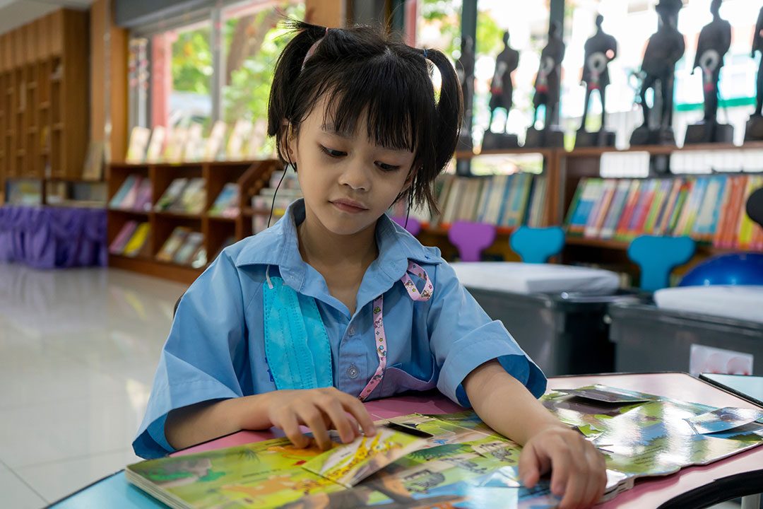 A Girl Student Sitting In The Library Reading A Bo 2024 05 27 02 40 09 Utc